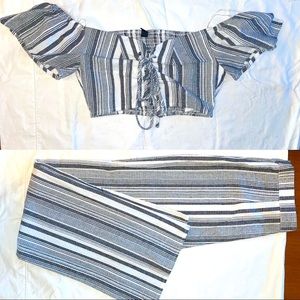 Black and white striped outfit. Off the shoulder frontal tie top. Zipper pants.